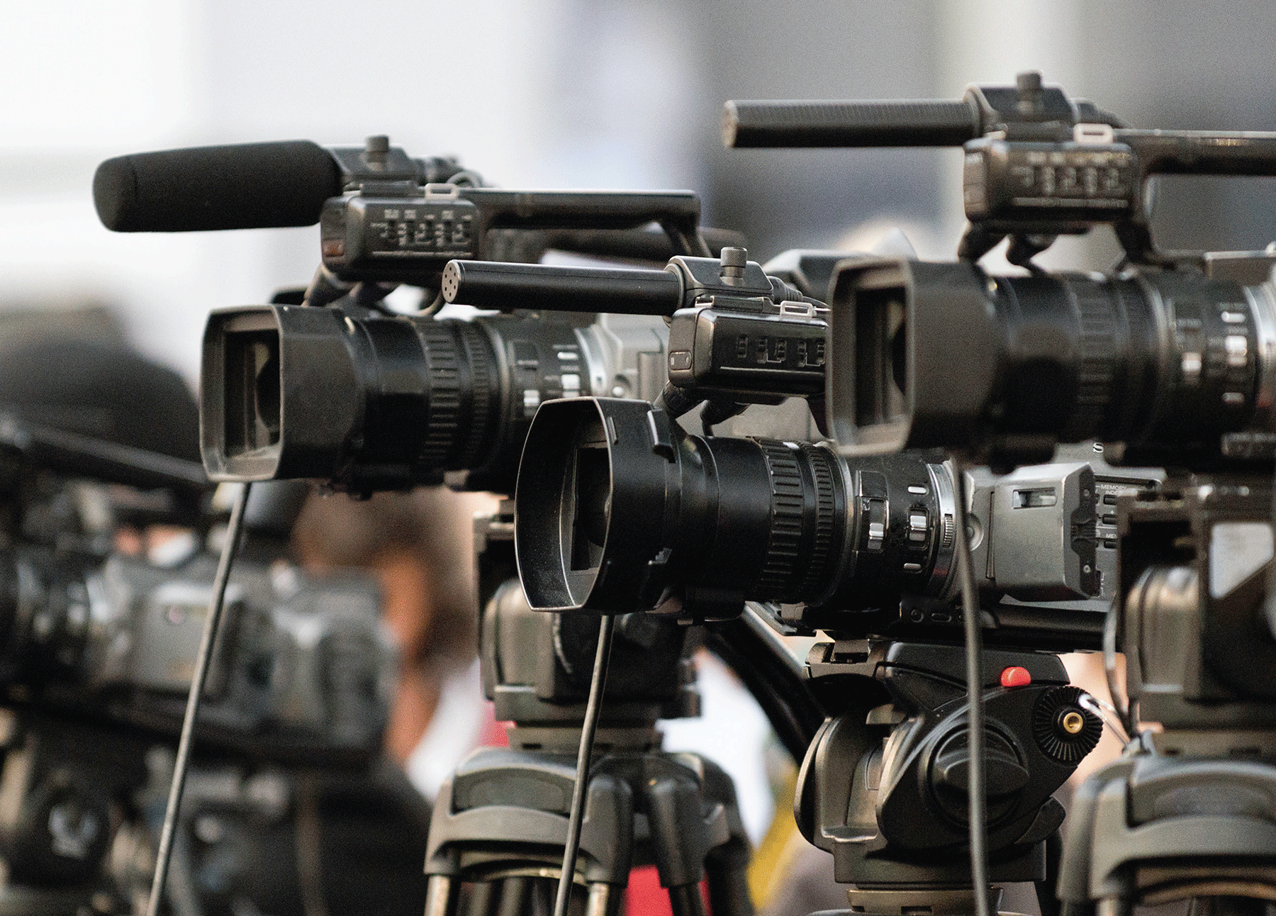 Multiple professional cameras on tripods aiming in the same direction