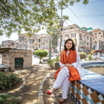 Sanam Maher sits on the ledge of an empty fountain in Pakistan