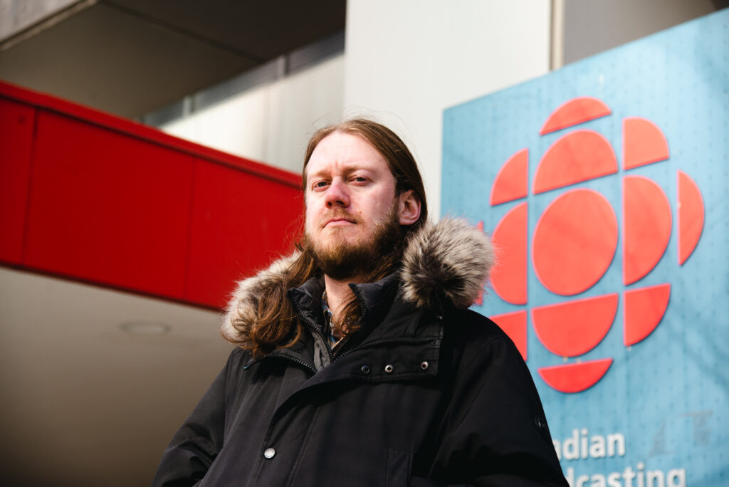 A portrait of Julian Uzielli in from of the CBC Toronto building.