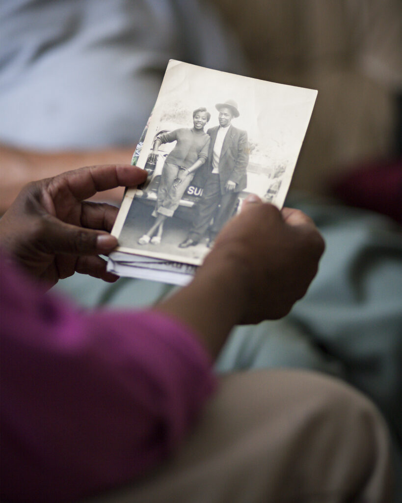 A person holds an old photograph of two people.