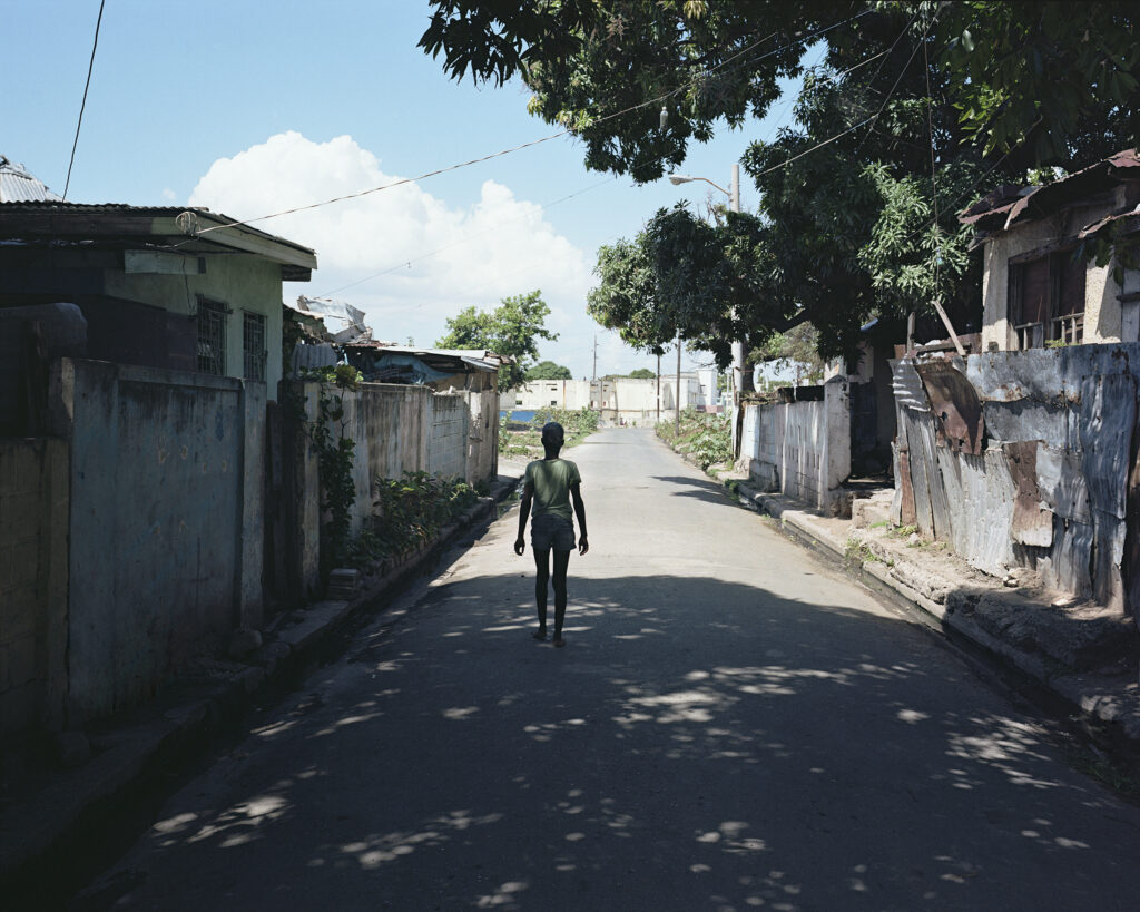 A boy stands in the shade on Pouyatt Street in Kingston, Jamaica, where photojournalist Andrew Jackson's mother once lived.