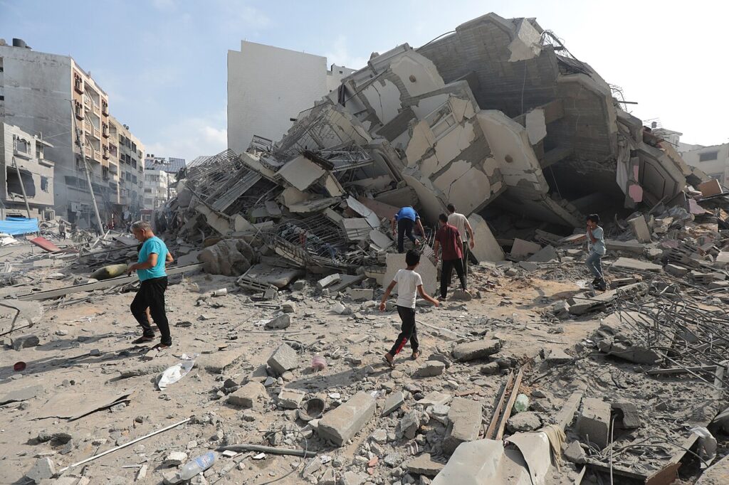 Palestinians inspect the ruins of Aklouk Tower destroyed by Israeli airstrikes in Gaza City on Oct. 8, 2023. Photo: Wikimedia Commons