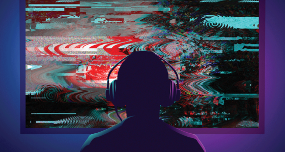 Someone sitting in front of a television screen with gaming headphones on