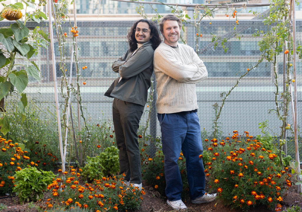 Chef Simon Toohey (right) and Aliyaan Amlani-Kurji (left) are pictured back to back at the Three Sisters Garden at the Daphne Cockwell Complex (DCC).