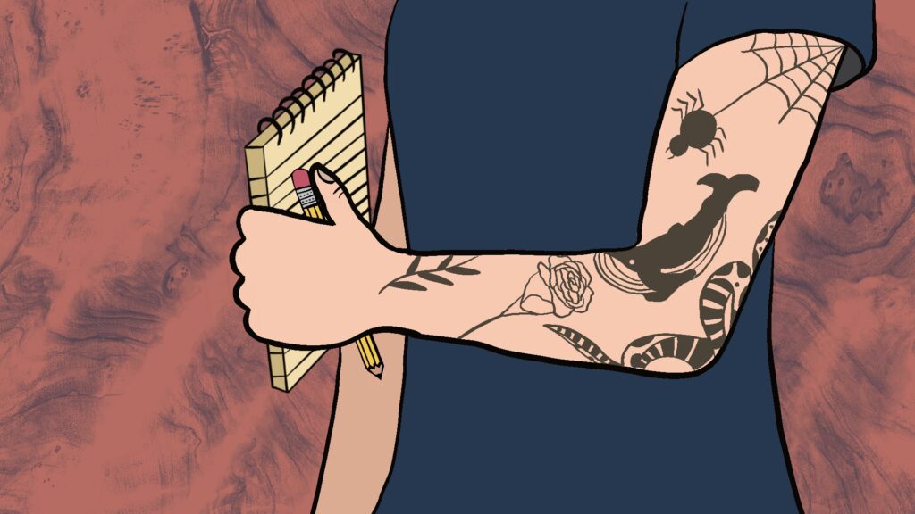 A tattooed arm holds a pen and a notepad