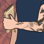 A tattooed arm holds a pen and a notepad