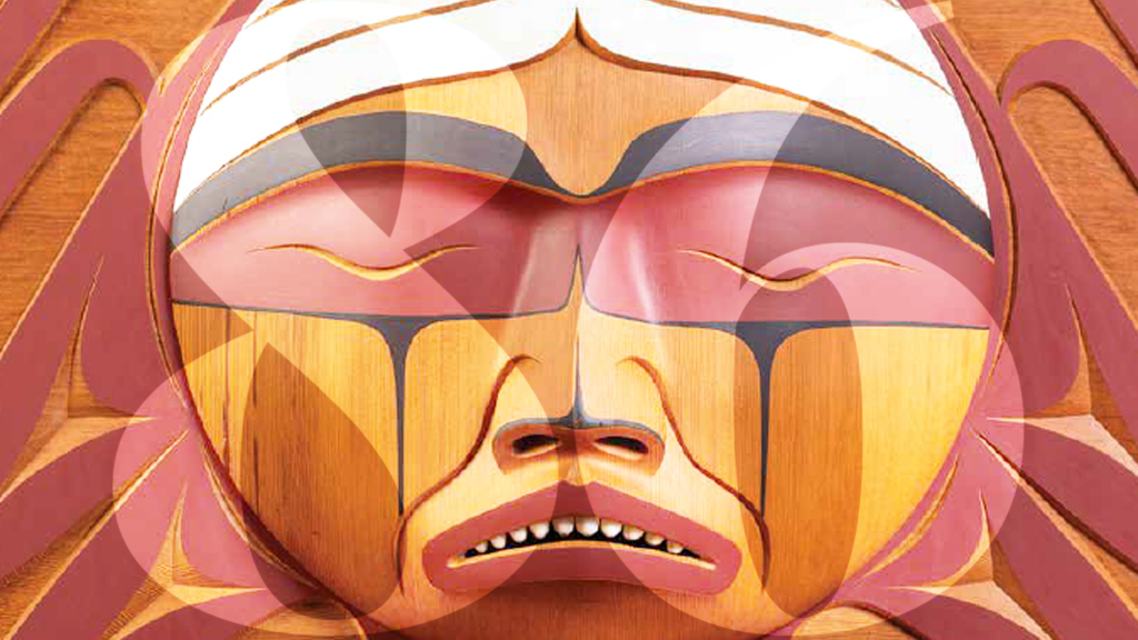 A white, black, red and orange wooden statue carved into the shape of a face with the number eighty-six faded in front of the statue.